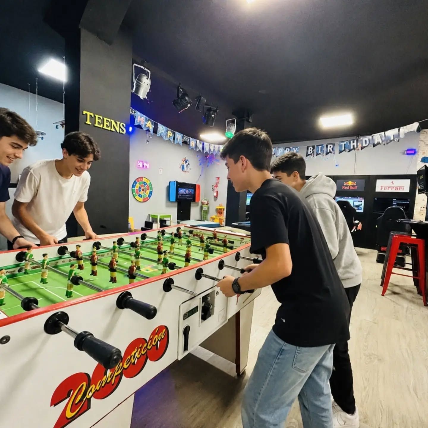 Grupo de adolescentes jugando al futbolín en un cumpleaños